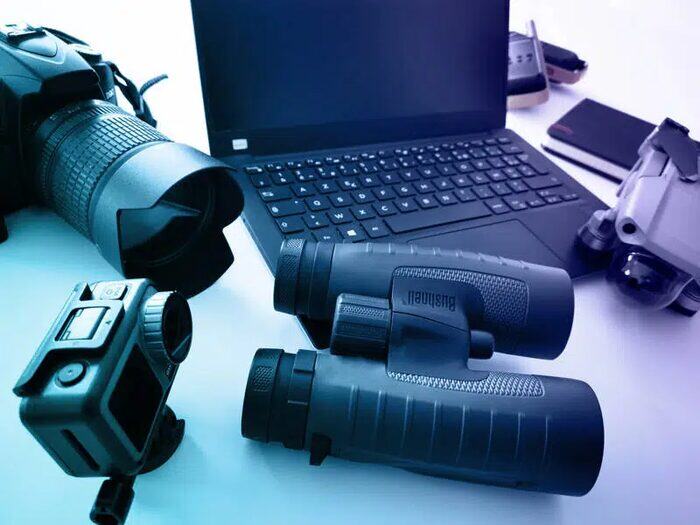 Full surveillance equipment: binoculars, camera, computer and GPS tracker